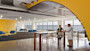 A female international student sits at a table at the University of Massachusetts Boston Venture Development Center startup incubator and speaks to a professor in a lab coat