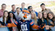 A group of international students at Auburn University stand behind Aubie the Tiger, the Auburn University school mascot.