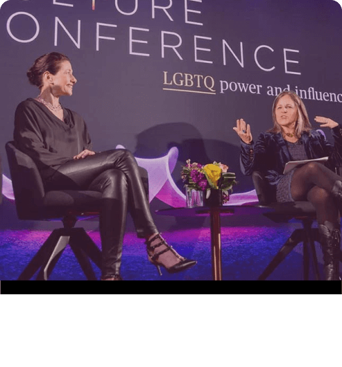 Three women sitting on stage and discussing