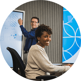 One female and two male P&G employees collaborating in P&G workspace. Female employee and P&G logo are at center of image and male employees are to each side.