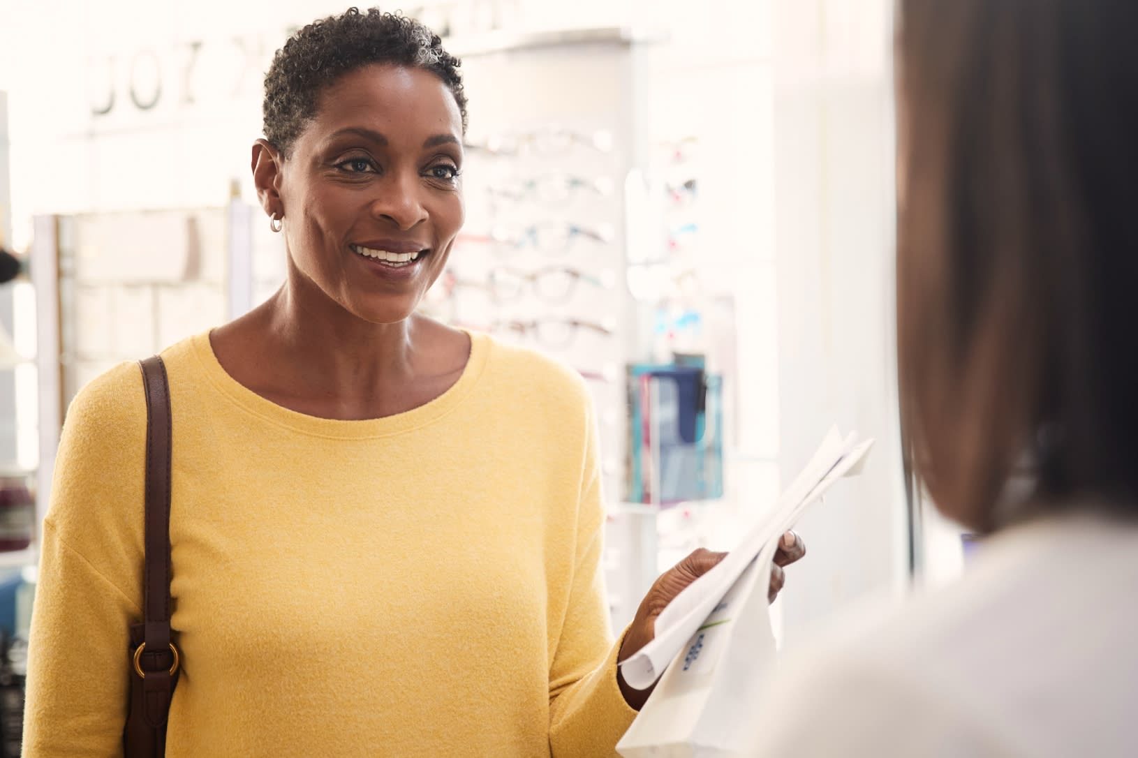 woman picking up prescription medication.