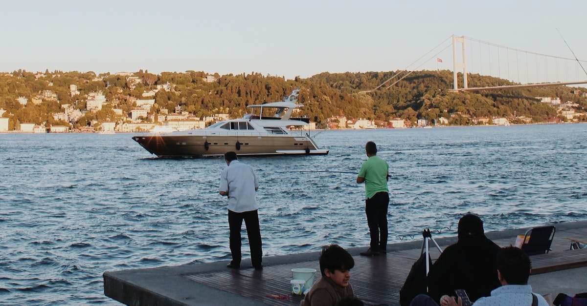 People Looking at the Yacht Sailing on the Ocean