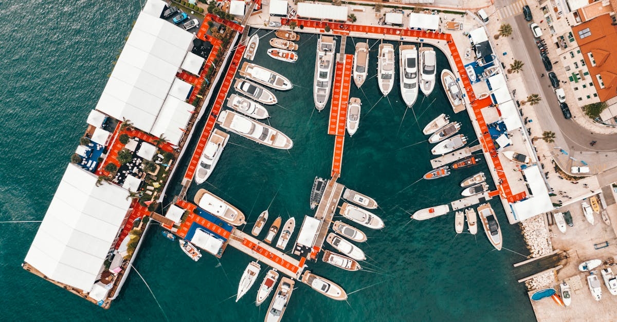 Picturesque aerial view of modern yachts moored in port located in Dubrovnik Old Town with red roofed historical buildings