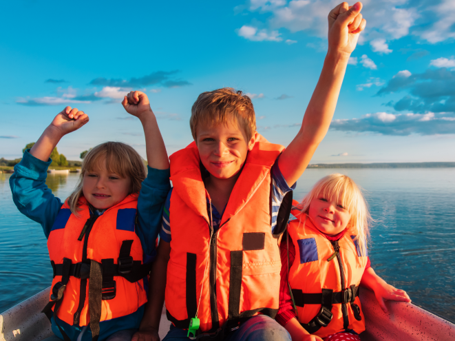 Happy kids wearing life jackets on the boat
