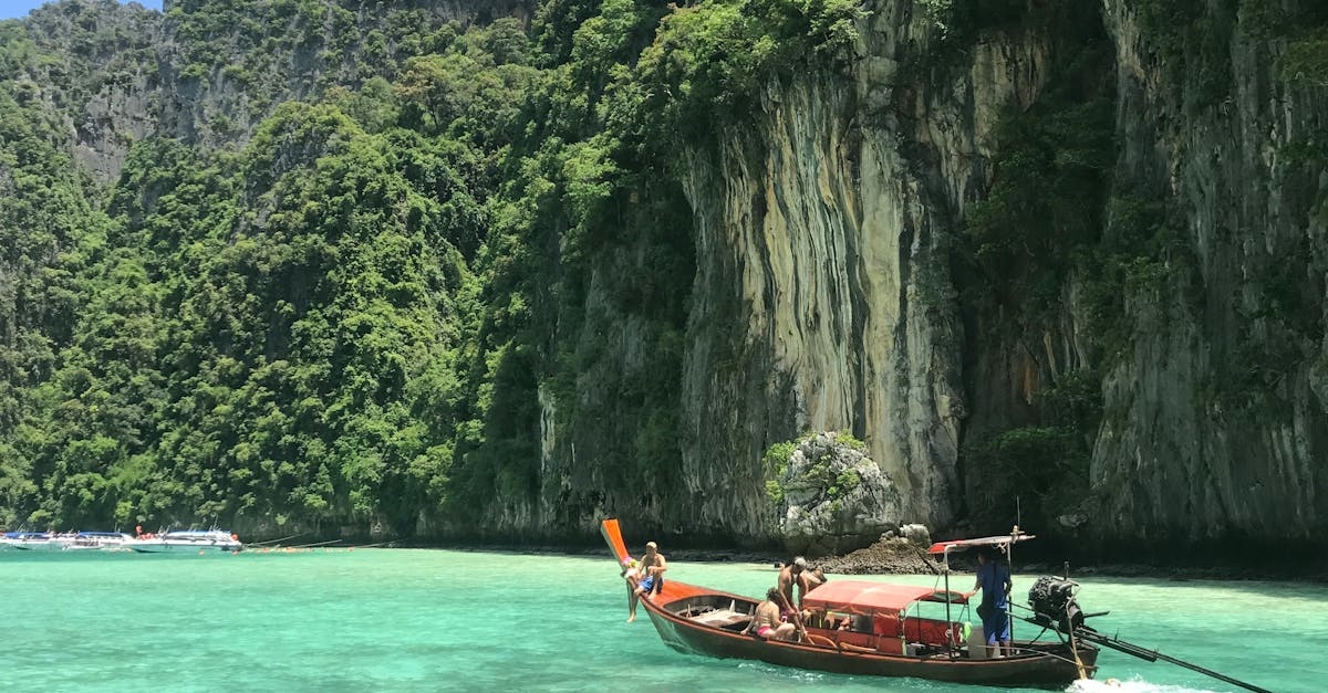 Small Boat in Body of Water Near a Cliff