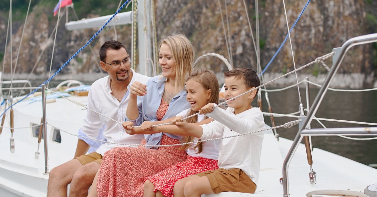 Full body of happy parents and children spending time together on sailboat in sea