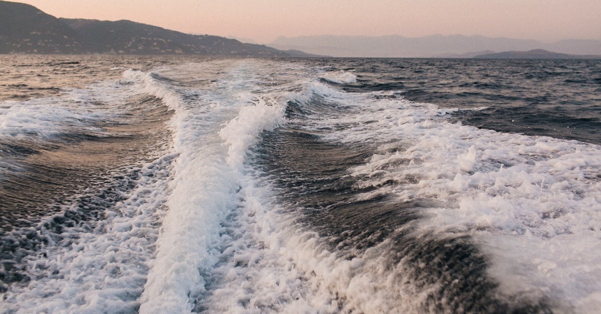 White splashes and foamy trails after motorboat on rough water of sea in dusk