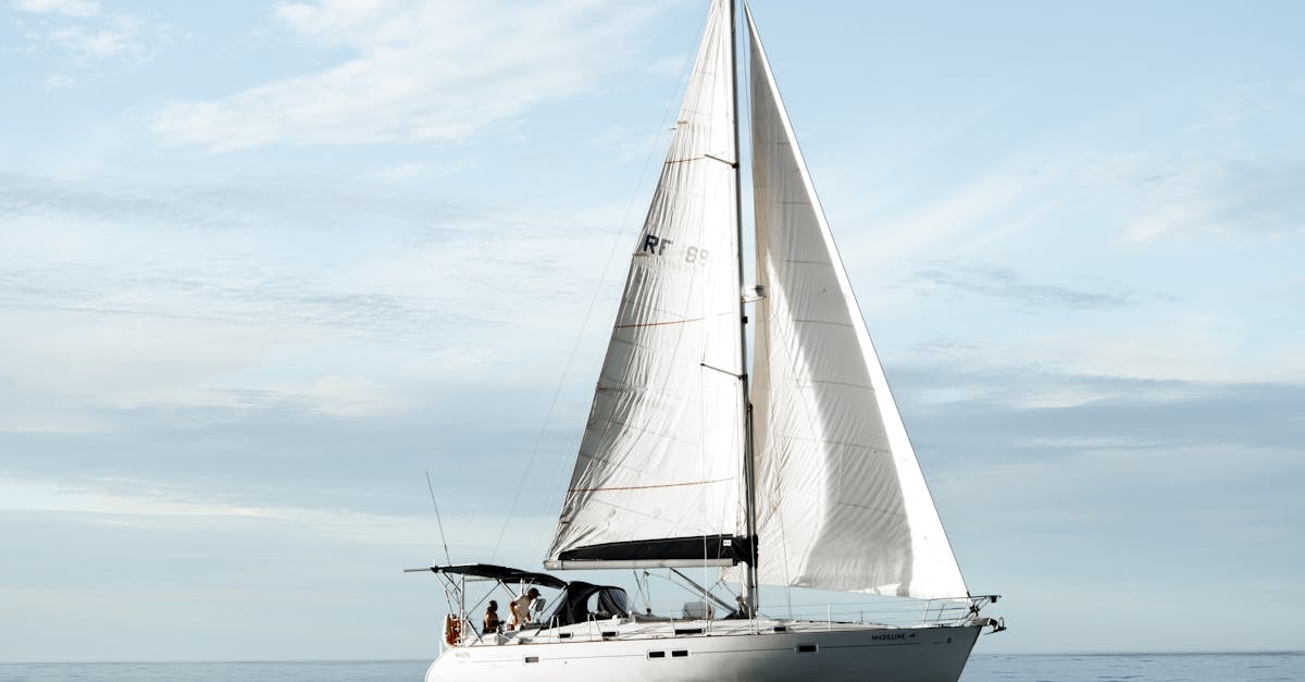 A Sailboat Floating on the Sea Under white Clouds