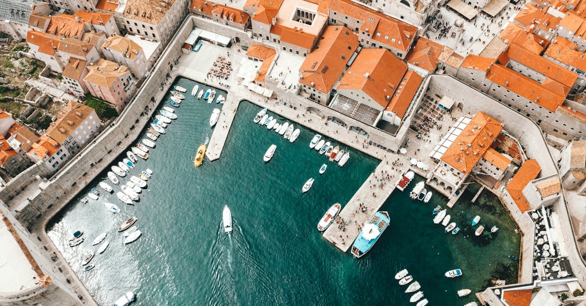 Breathtaking drone view of coastal town with traditional red roofed buildings and harbor with moored boats in Croatia
