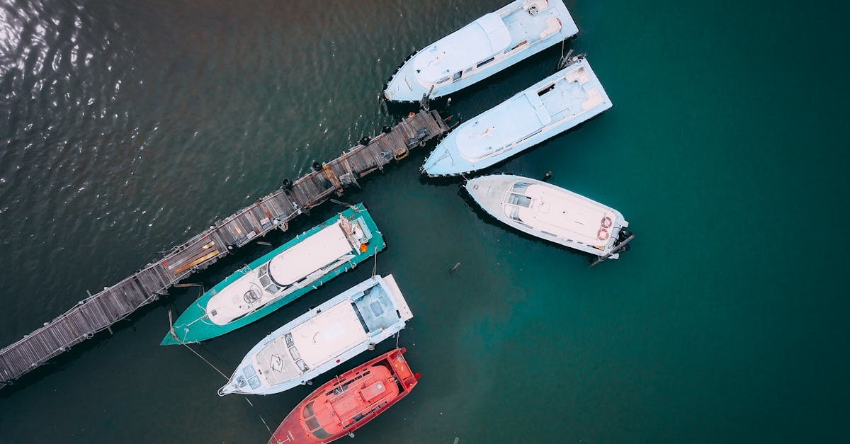 Boats moored near wooden quay in sea