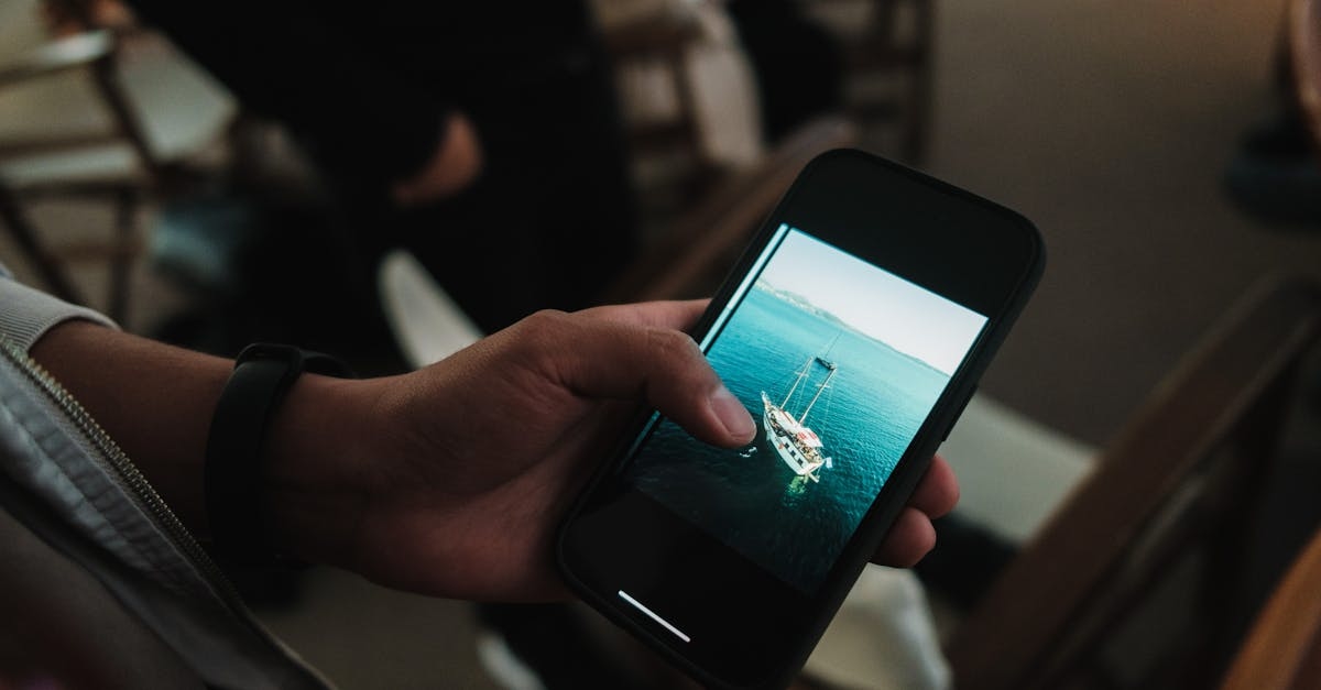 A person holding a cell phone with a photo of a boat