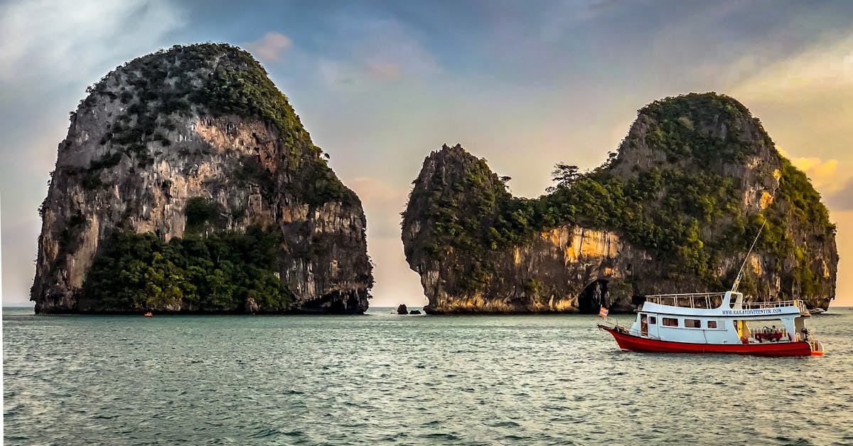 White Boat Sailing Near Islands during Golden Hour