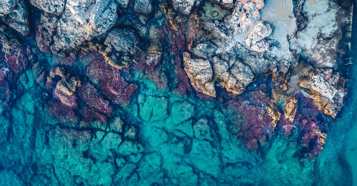 Aerial Photography of Rocks Beside Body of Water