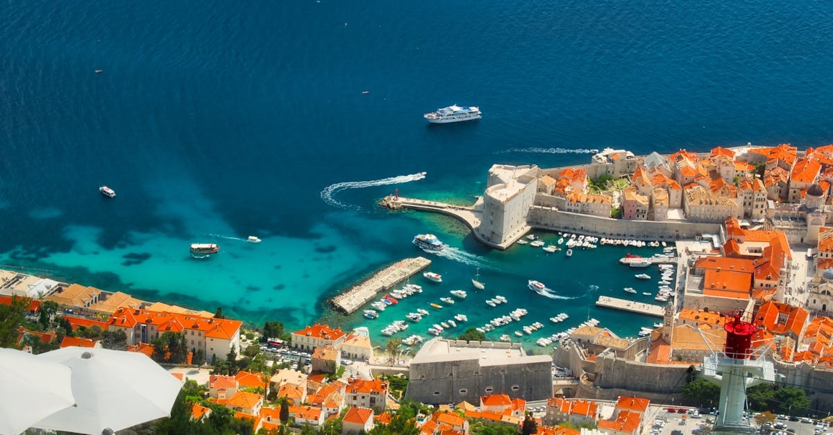Aerial View of City Buildings and Marina Near Blue Sea