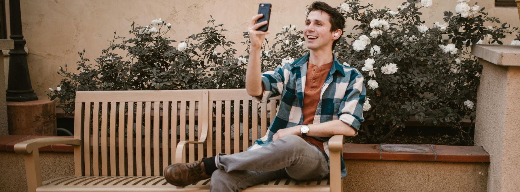 a man engaging in virtual language exchange on his cell phone 