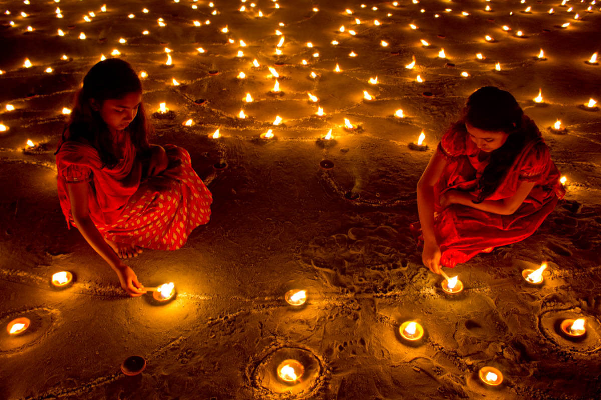 Girl lighting candles for Diwali festival