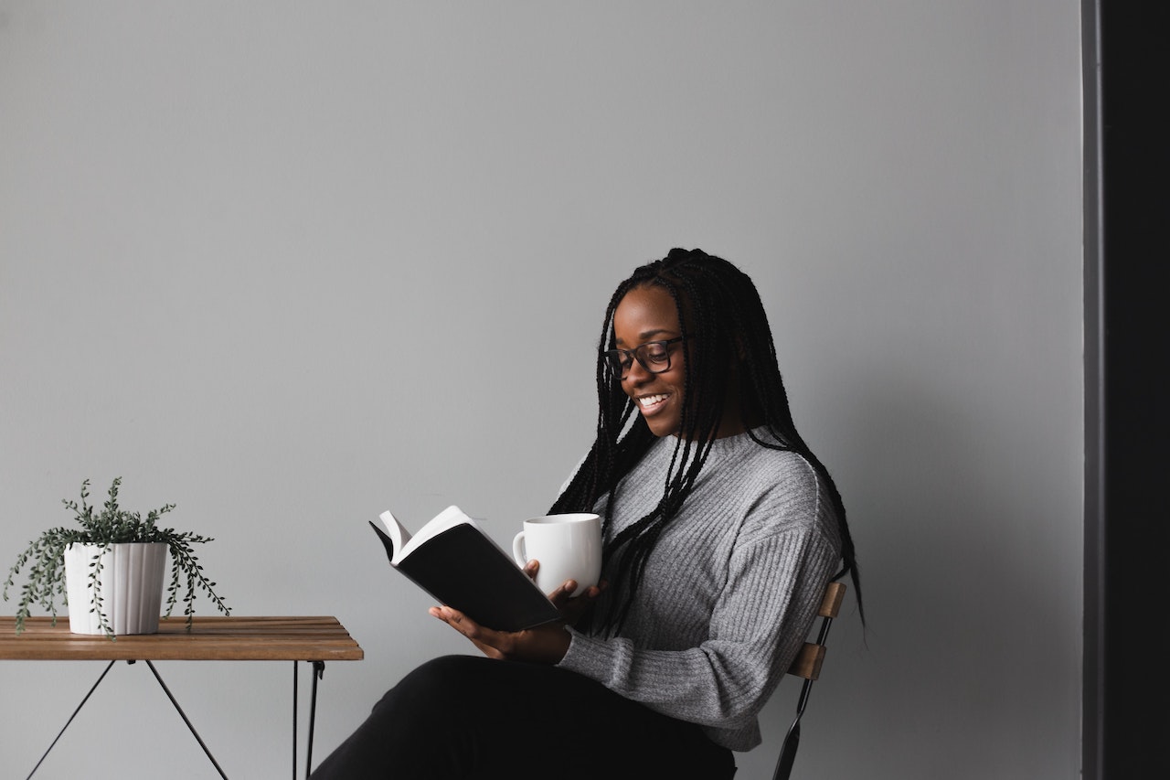 girl reading book with coffee in hand