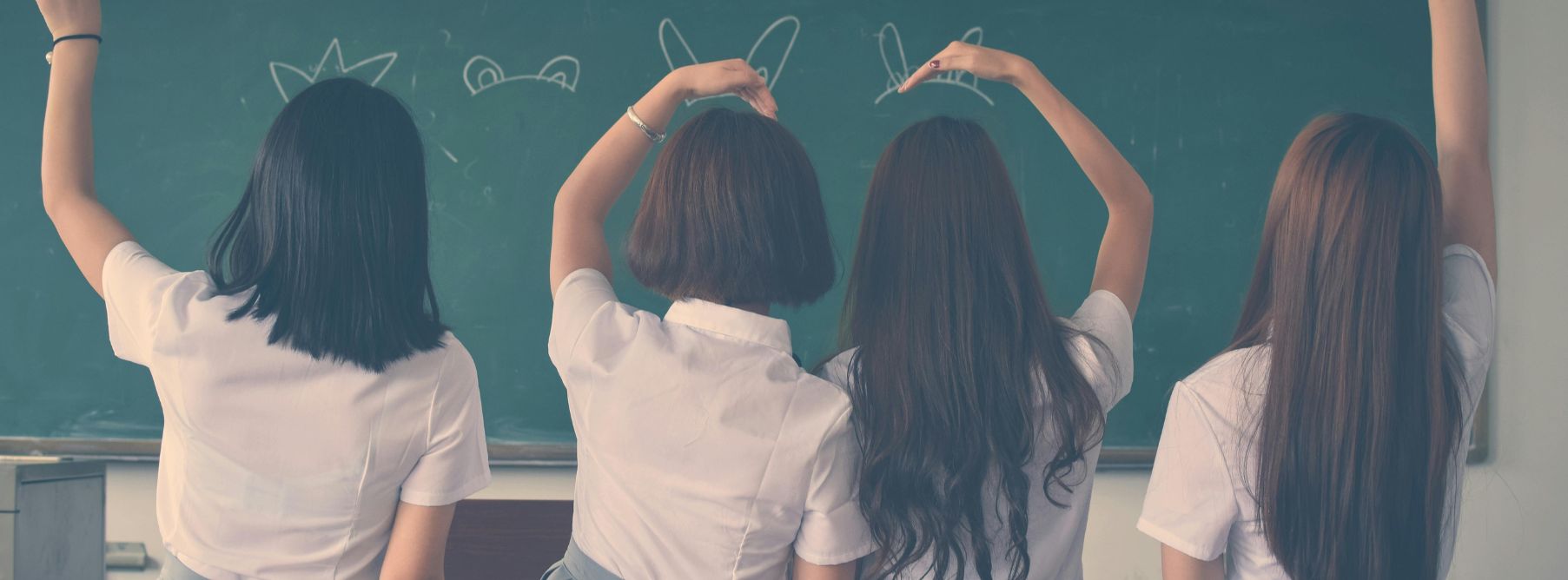 four girls sitting on a desk with korean girl names