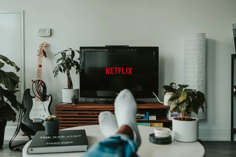 человек смотрит netflix по телевизору