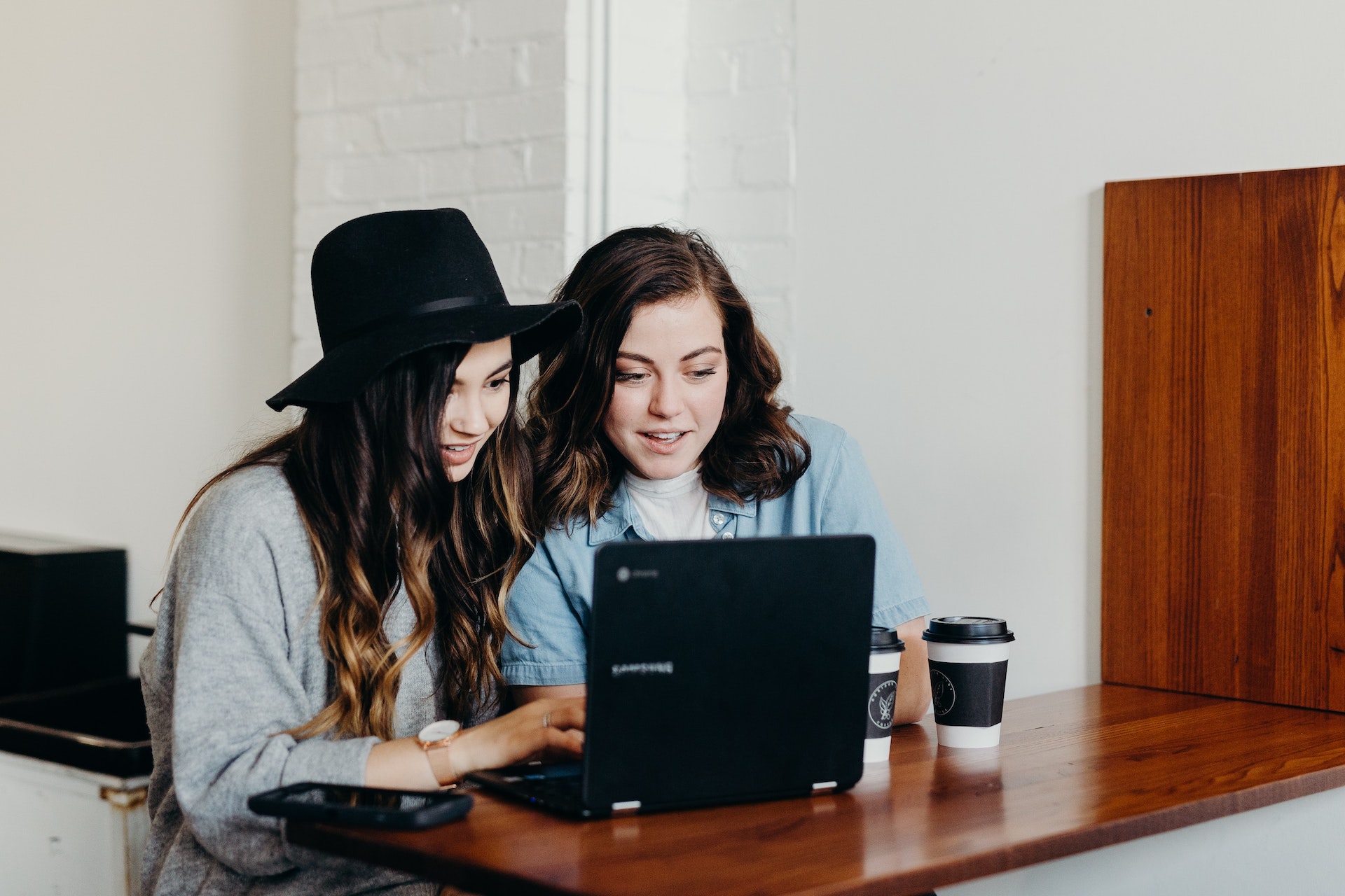 two girls working together on laptop