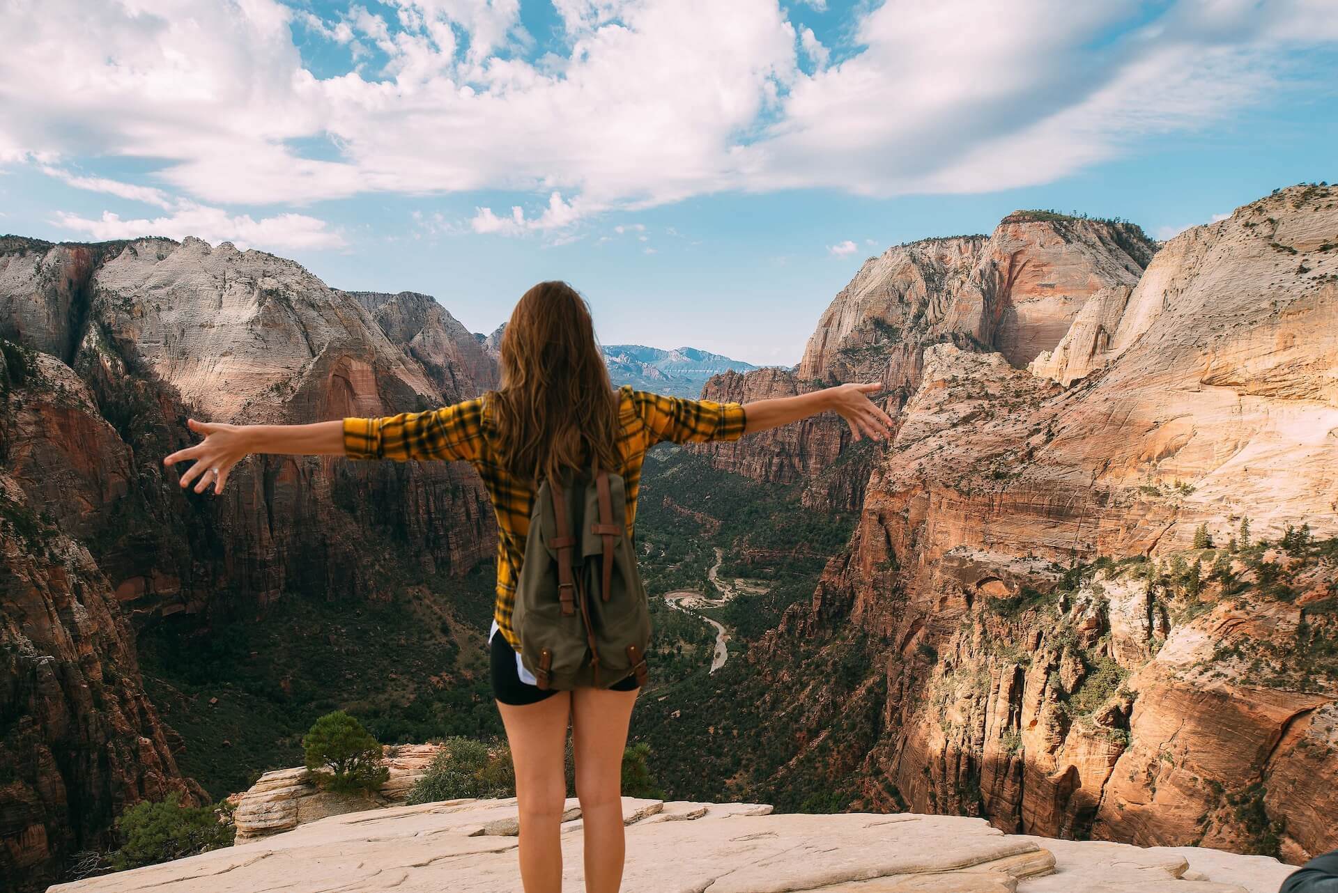 girl on top of mountain with open arms