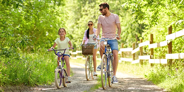Eltern und Kind die im Frühling gemeinsam Rad fahren