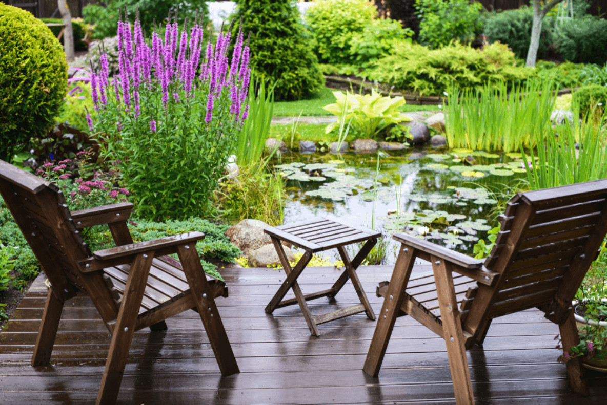 Eine Sitzgelegenheit um den Gartenteich lädt zum Entspannen ein.