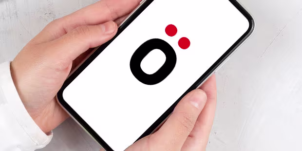Hände die ein refurbished Smartphone halten, auf einer Arbeitsfläche in Betonoptik