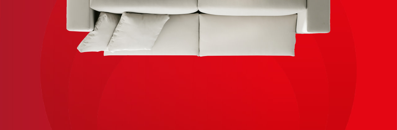 Beiges Sofa auf rotem Hintergrund