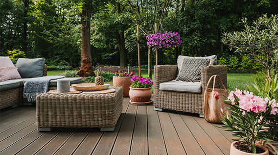 Geschmackvoll eingerichtete Terrasse mit Garten in Hintergrund