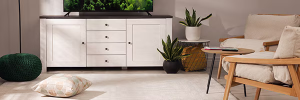 Ein stilvoll eingerichtetes Wohnzimmer das mit Pflanzen und Heimtextilien zum Entspannen einlädt | shöpping.at