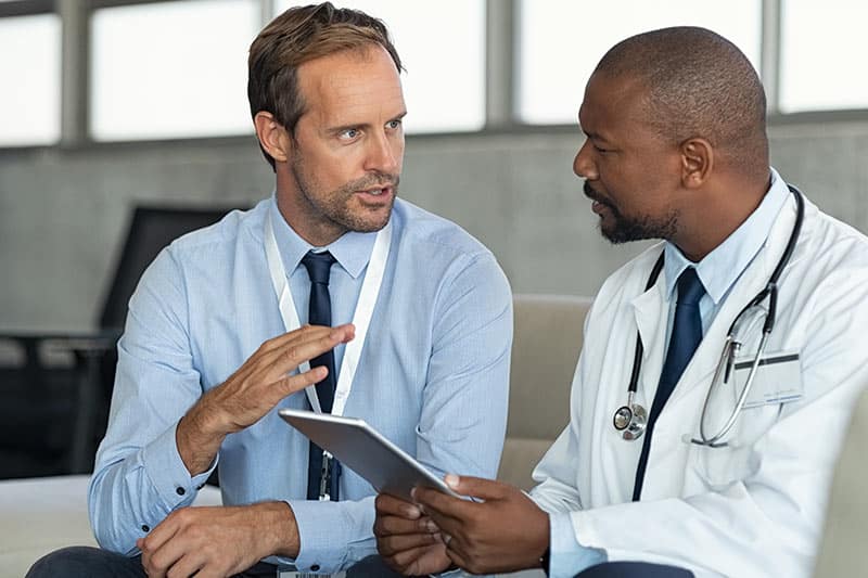 A medical device rep in conversation with a physician