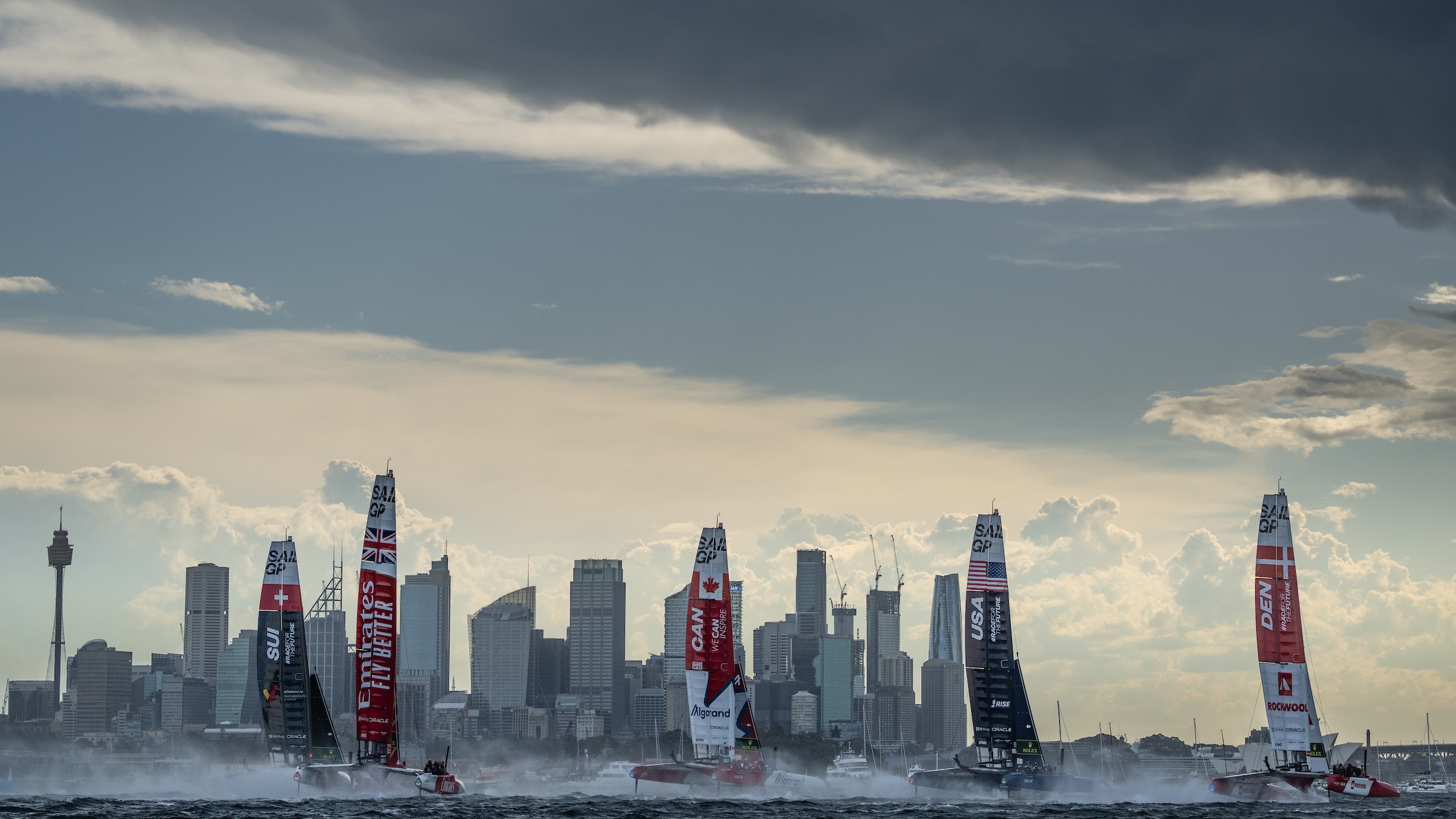 Season 3 // SailGP Fleet against stormy background of Sydney