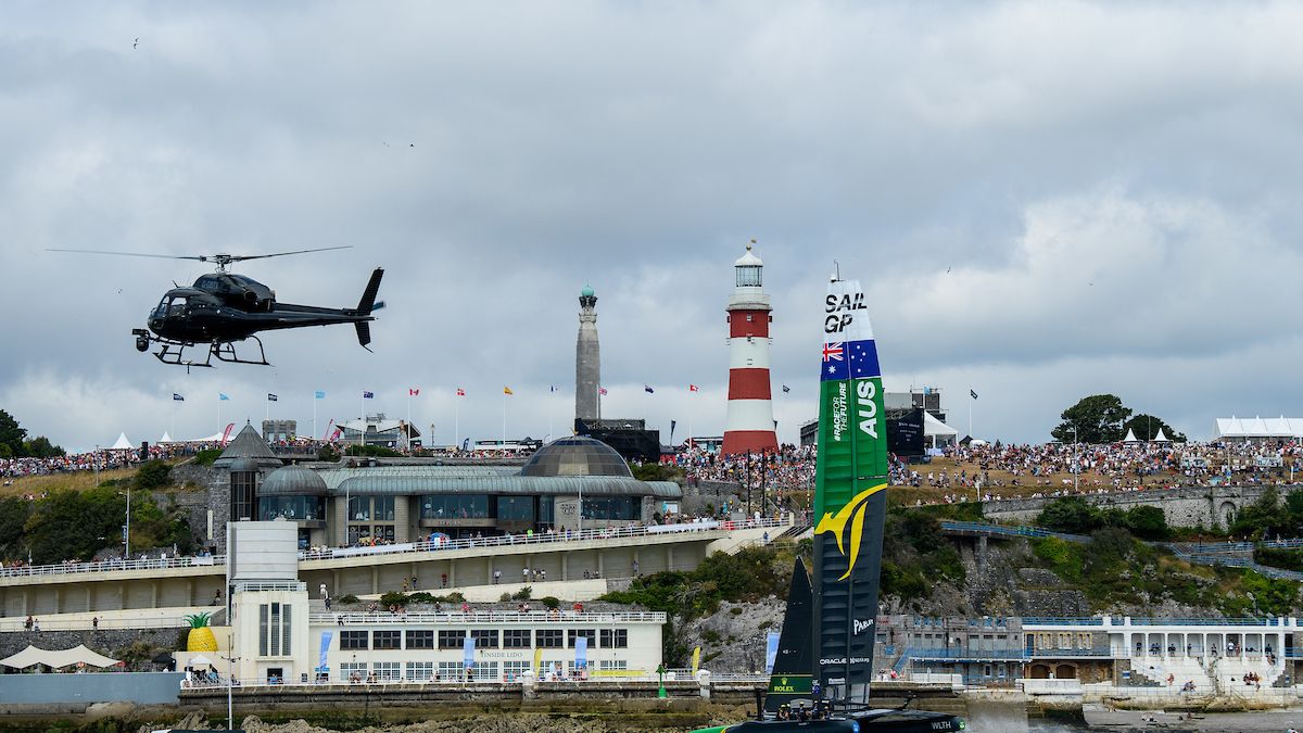 The helicopter flies past Australia against the backdrop of Plymouth Hoe