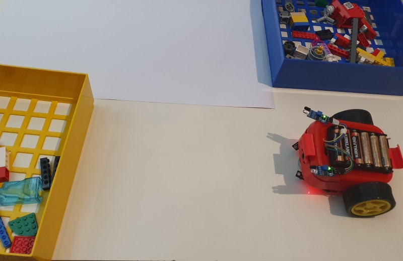 Lunchbox robot in our colour-controlled test area. The robot's camera sees which colour wall is in front of it. The robot uses this information to choose which way to turn