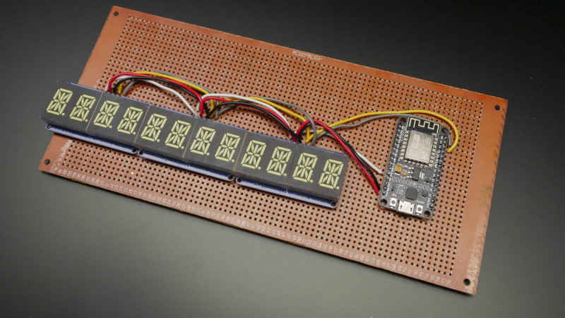 The microcontroller lives on the perfboard next to the alphanumeric displays, and the USB port points down to provide the easiest cable routing