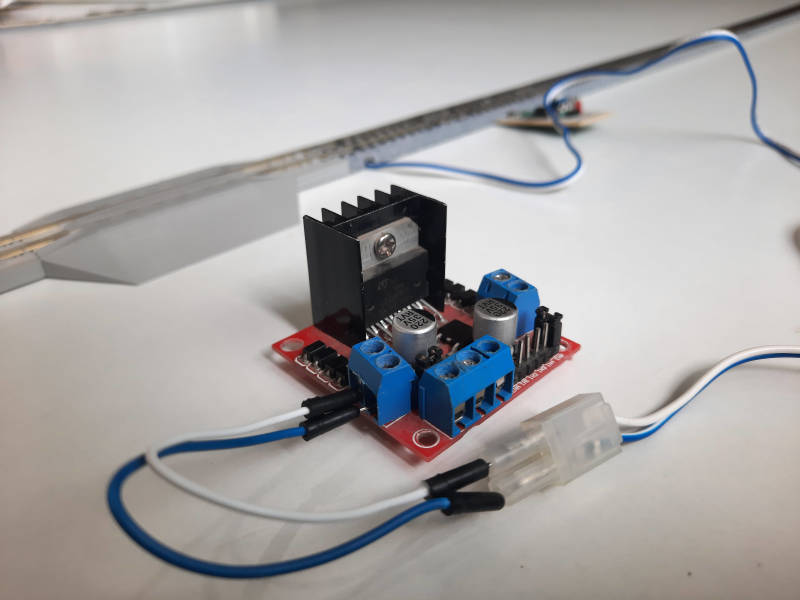 Connect the wires of the track power block to the outputs of the motor driver, then connect the female DC jack positive wire to the +12 V terminal. Connect a male jumper and the DC jack’s negative wire to the GND (centre) terminal, and a jumper wire to the +5 V (right) terminal of the motor driver.