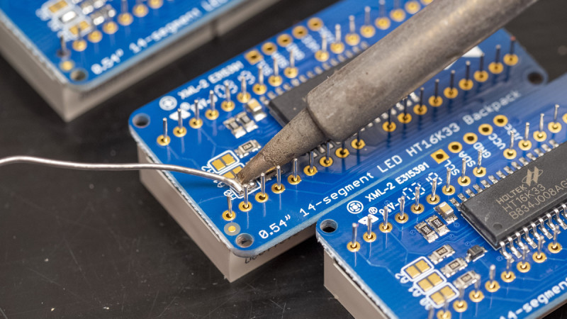 To bridge the solder pads, touch your hot soldering iron to both at once, then apply some solder to the heated pads, which should blob over both pads. If it doesn’t look even and shiny at first, try reheating the joint