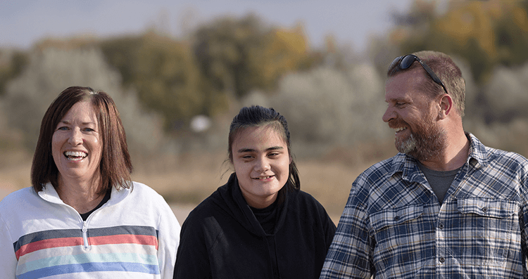 Ellie,age 15, living with Rett syndrome, with her parents
