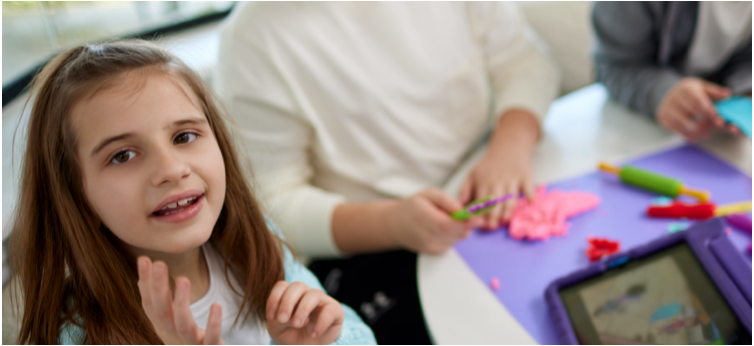 Kate, age 9, living with Rett syndrome, playing with a tablet and doing crafts with her mom