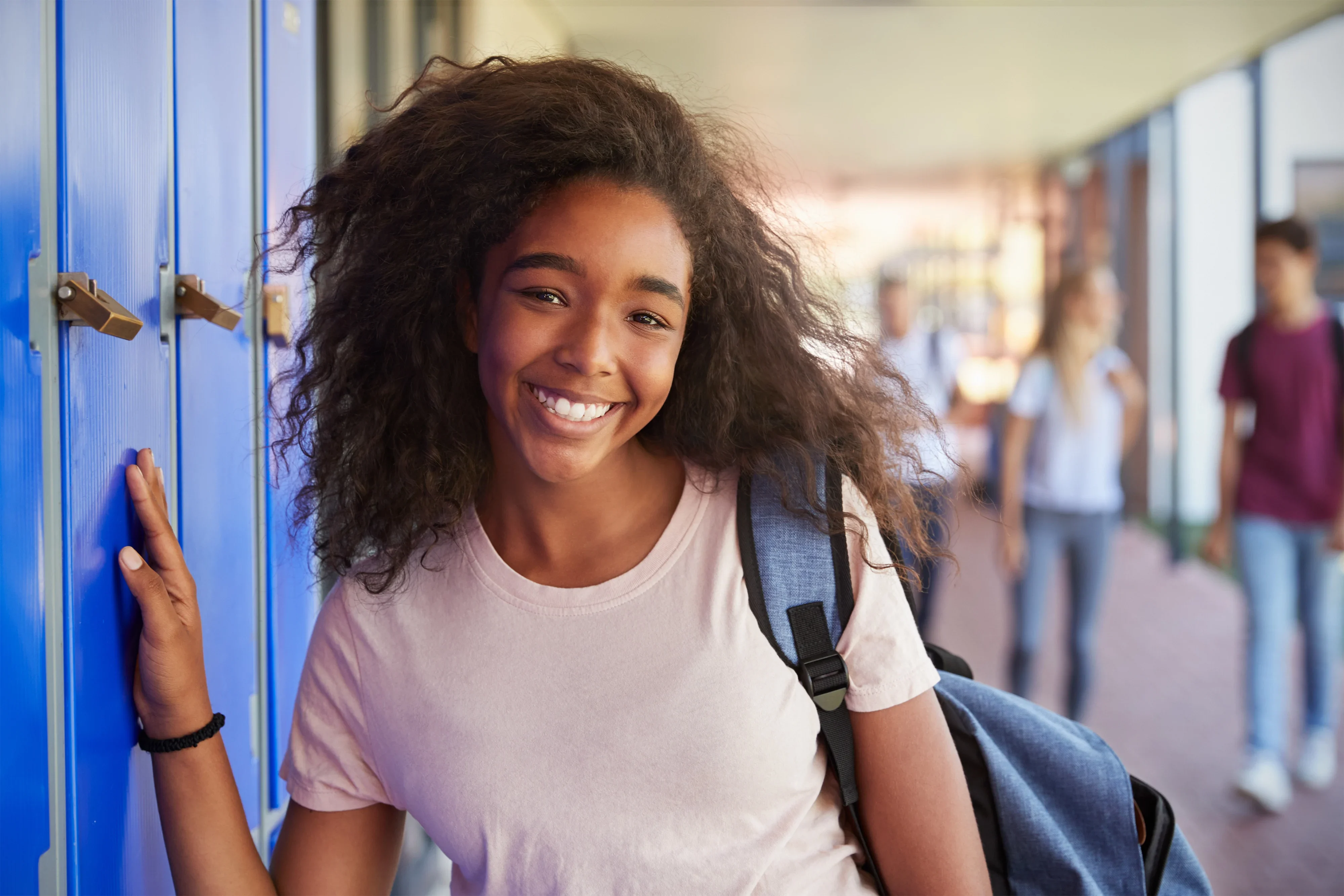 Fille souriante avec sac à dos à l'école