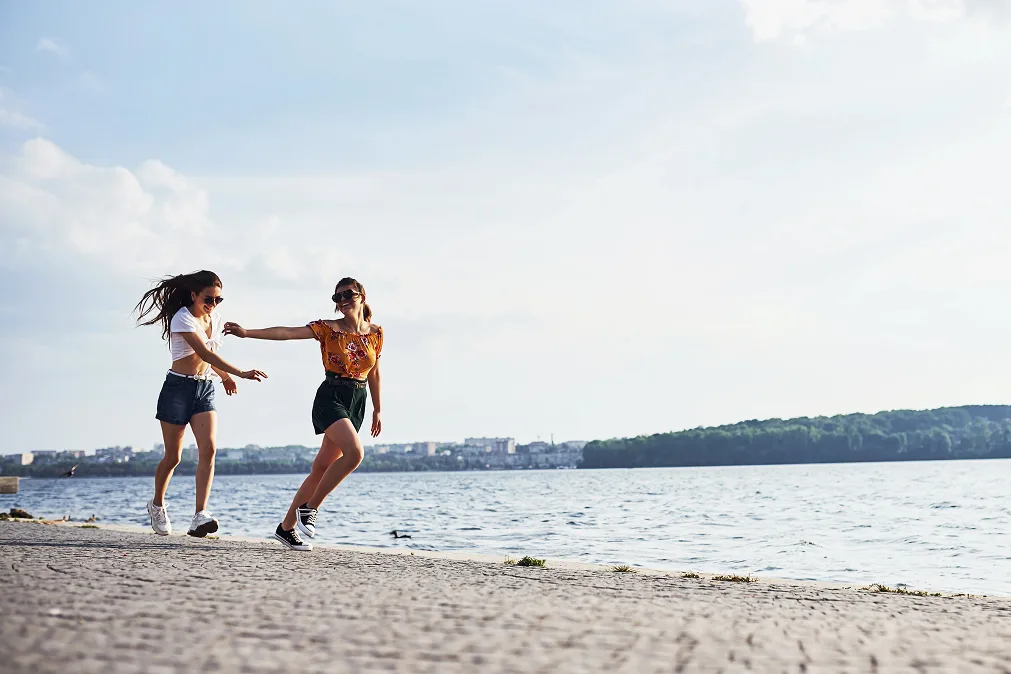 Quatre filles qui rient marchant sur la plage