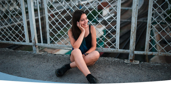 Jeune fille souriante assise sur le pont
