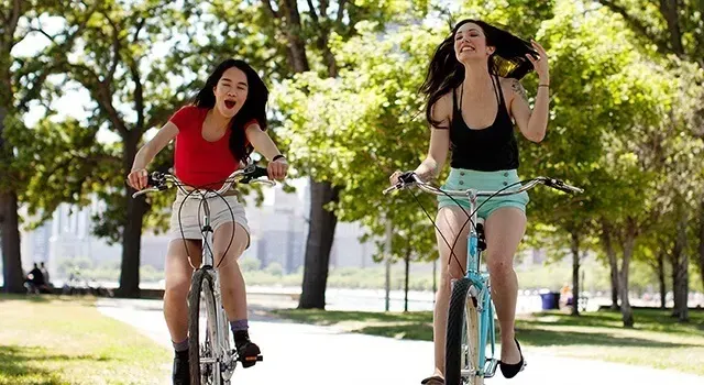 Deux jeunes filles la bicyclette à l'extérieur