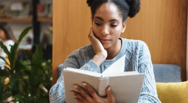 Jeune fille souriante lisant un livre