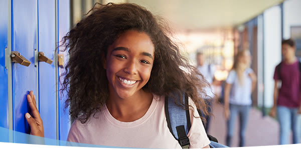 Fille souriante avec sac à dos à l'école