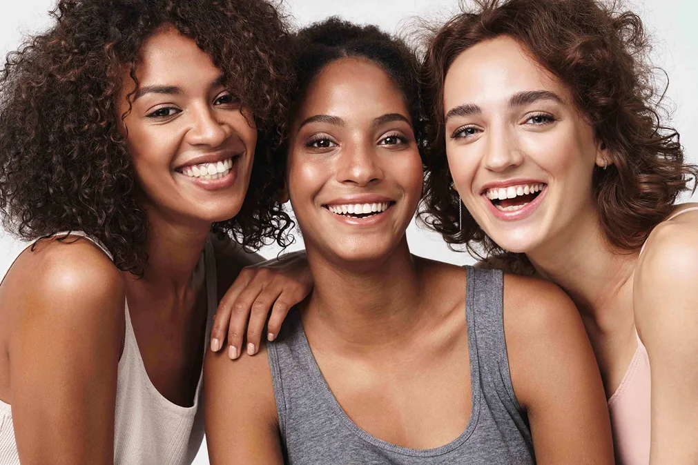 Trois jeunes femmes souriantes  