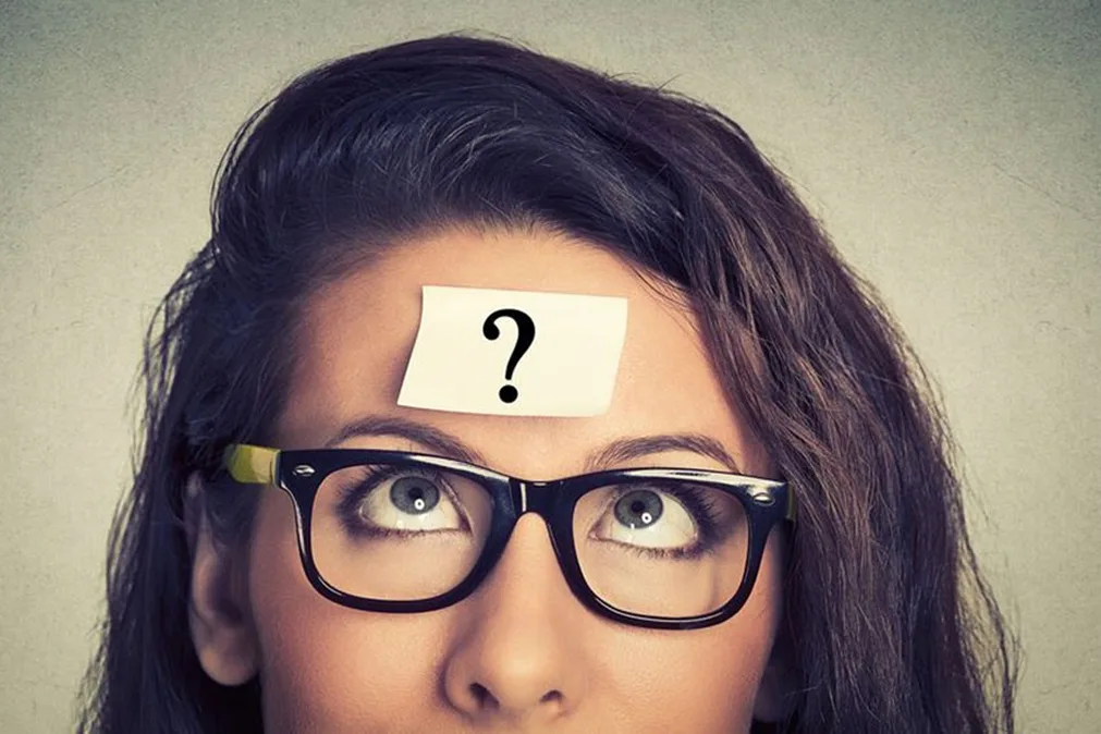 Femme pensive avec l'étiquette du point d'interrogation sur le front