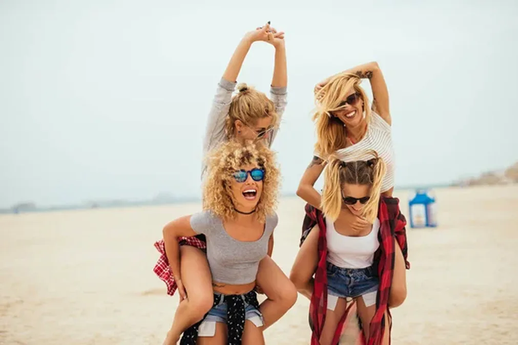 Quatre filles souriantes sur la plage