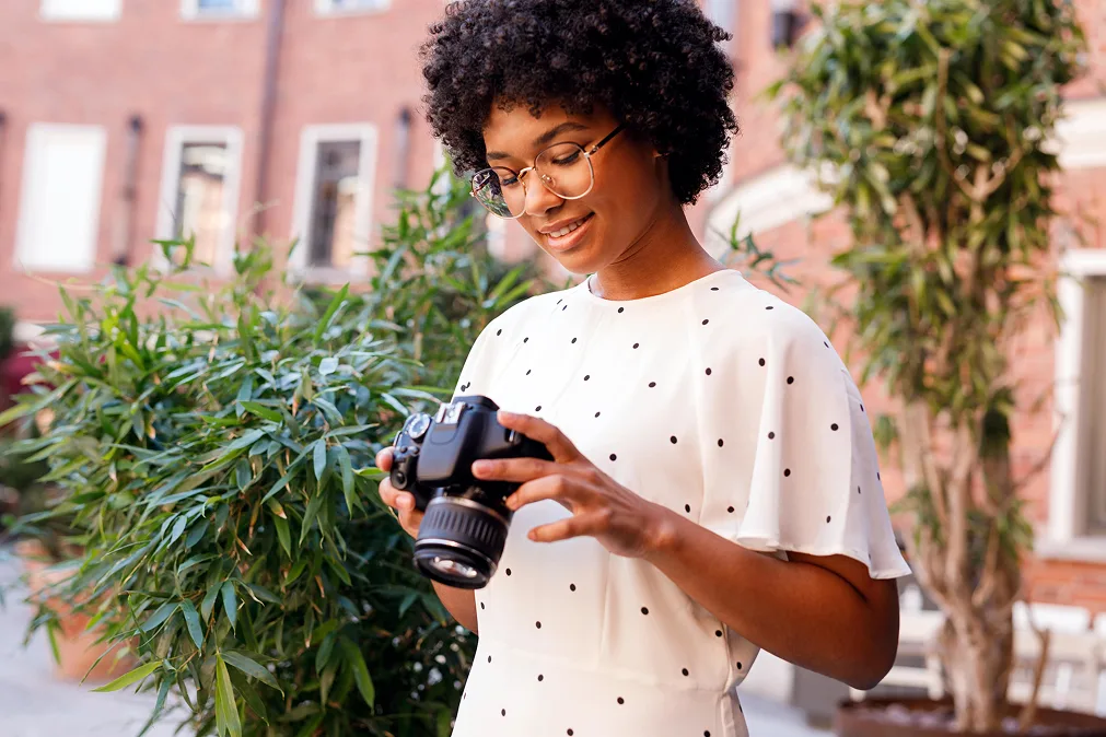 Jeune fille souriante avec un appareil photo